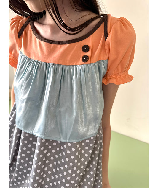 Unsocial Night short sleeve top showcasing a whimsical polka dot print, structured puff sleeves, contrast patchwork, and a voluminous bubble hem