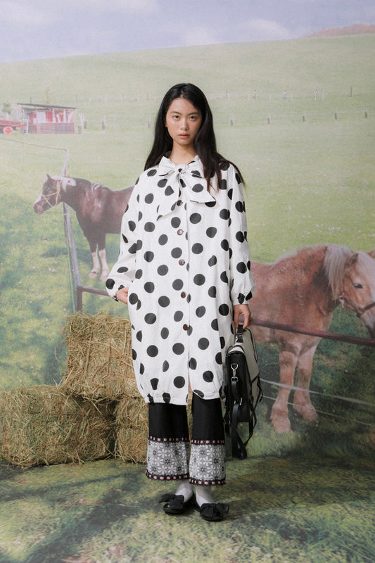 Front view of Unsocial Night oversized vintage polka dot trench coat showcasing the relaxed longline silhouette, classic button closure, and timeless dot pattern