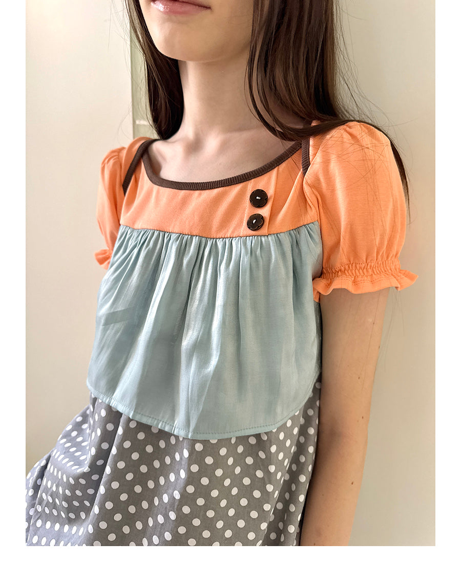 Unsocial Night short sleeve top showcasing a whimsical polka dot print, structured puff sleeves, contrast patchwork, and a voluminous bubble hem
