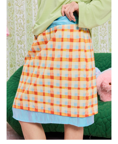 Front view of Unsocial Night orange color block plaid drawstring tube skirt top showing its convertible H-line silhouette, elastic waist, and patchwork details