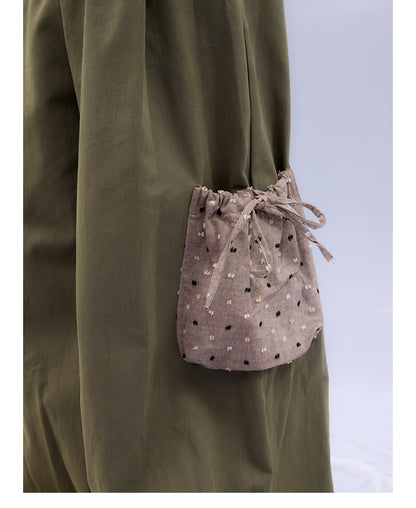 Front view of Unsocial Night moss green cargo pants featuring a paperbag waist silhouette, utility pockets, zipper fly, and textured cotton-linen fabric