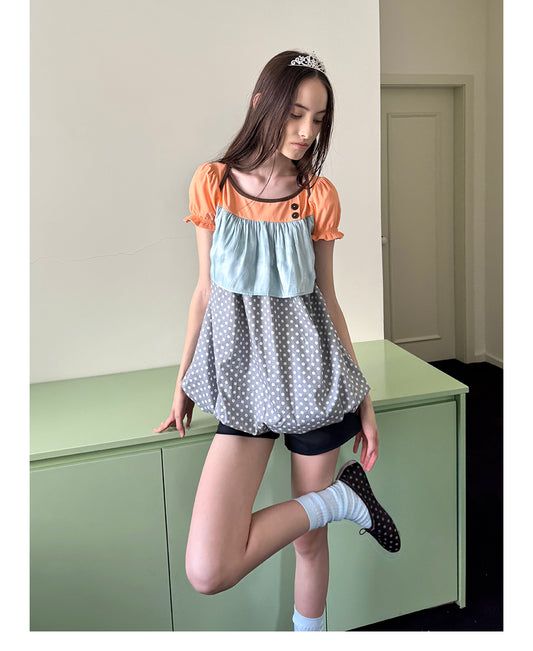 Unsocial Night short sleeve top showcasing a whimsical polka dot print, structured puff sleeves, contrast patchwork, and a voluminous bubble hem