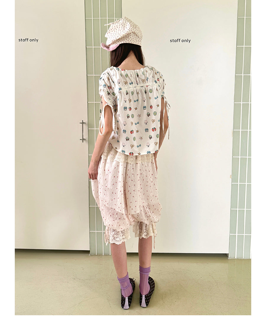 Unsocial Night short sleeve top showcasing a whimsical naive-art illustration print, central ruched detailing, and functional front ribbon ties