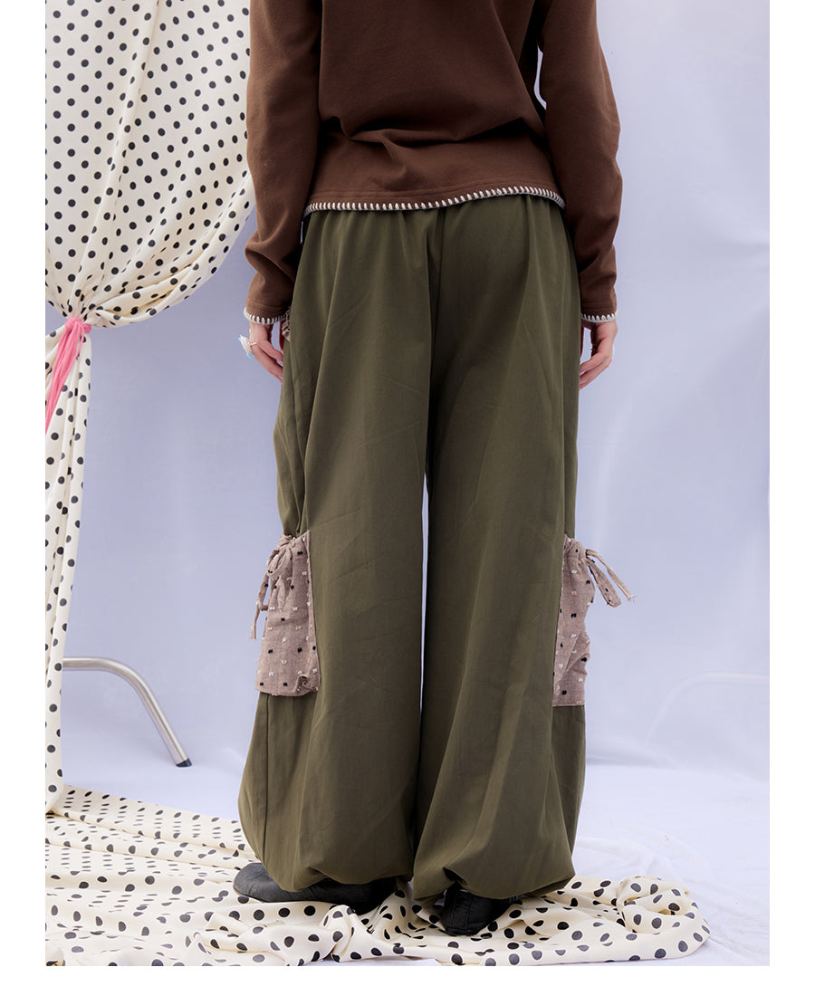Front view of Unsocial Night moss green cargo pants featuring a paperbag waist silhouette, utility pockets, zipper fly, and textured cotton-linen fabric