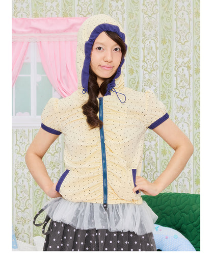 Front view of Unsocial Night short jacket top featuring an all-over polka dot print, a cozy attached hood, short puff sleeves, and a zip-up closure.