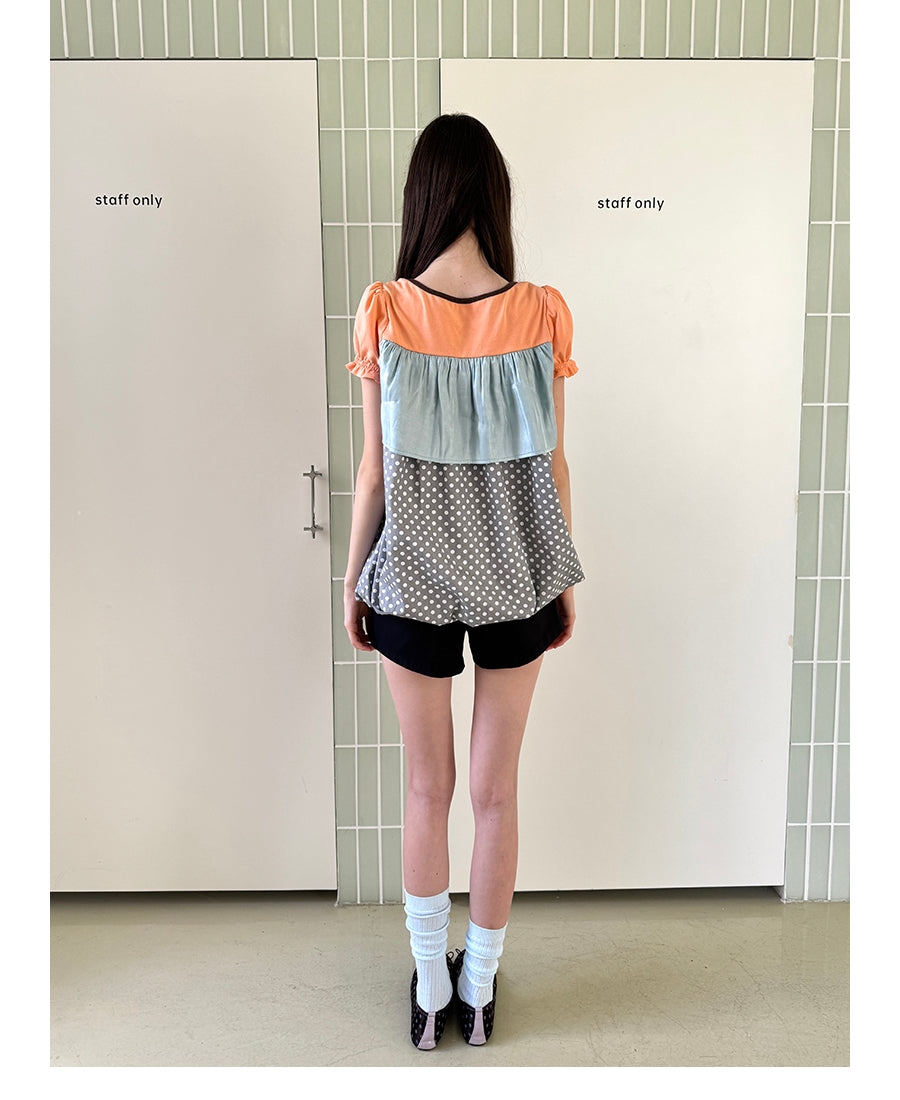 Unsocial Night short sleeve top showcasing a whimsical polka dot print, structured puff sleeves, contrast patchwork, and a voluminous bubble hem