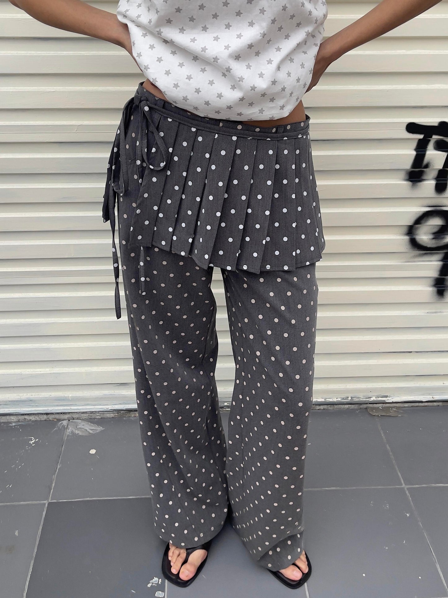 Front view of Unsocial Night pleated polka dots skirt pants 2-piece set showcasing the layered micro-pleated skirt over matching fluid wide-leg trousers
