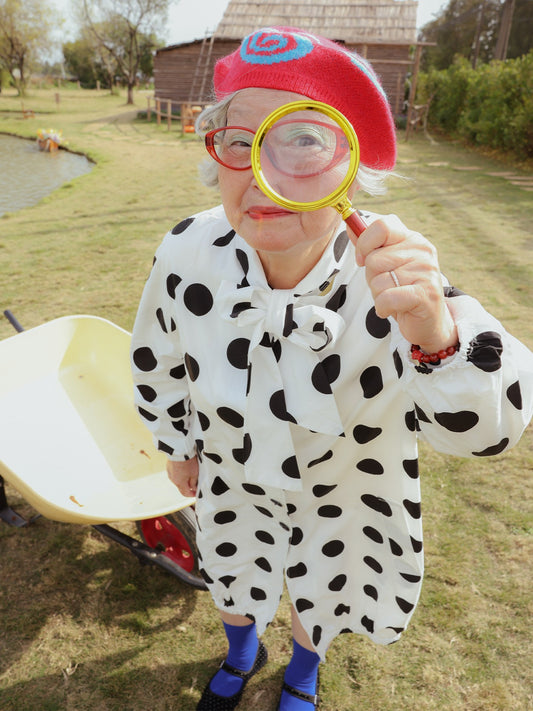 Front view of Unsocial Night oversized vintage polka dot trench coat showcasing the relaxed longline silhouette, classic button closure, and timeless dot pattern
